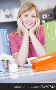 Young woman sitting at a table taking a break from shopping