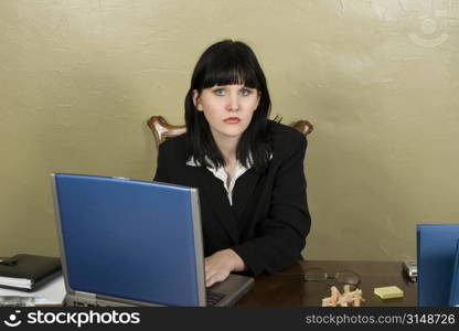 Young woman sitting at desk. Tired expression.