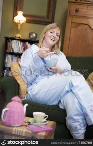 Young woman sitting at home eating a sweet treat