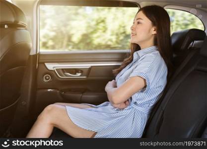 young woman sitting at the back seat of car