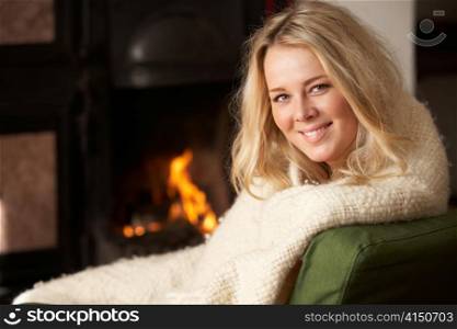 Young woman sitting by open fire