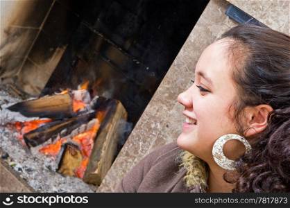 Young woman sitting by the fire during a game of cards