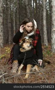 young woman sitting forest with her dog