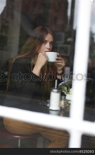 Young woman sitting in a cafe having a cup of coffee