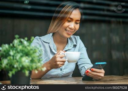 young woman sitting in a coffee shop and playing smart phone
