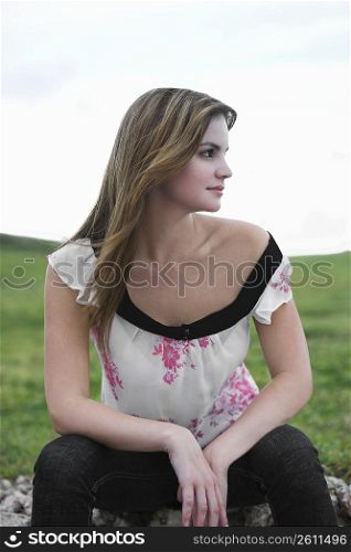 Young woman sitting in a field