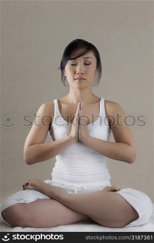 Young woman sitting in a prayer position