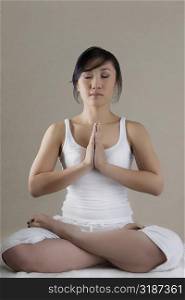 Young woman sitting in a prayer position