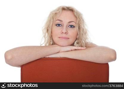Young woman sitting in a red armchair isolated over white