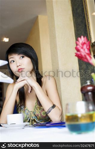 Young woman sitting in a restaurant and looking away