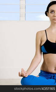 Young woman sitting in a yoga position