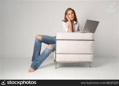 Young Woman Sitting in Armchair With Laptop