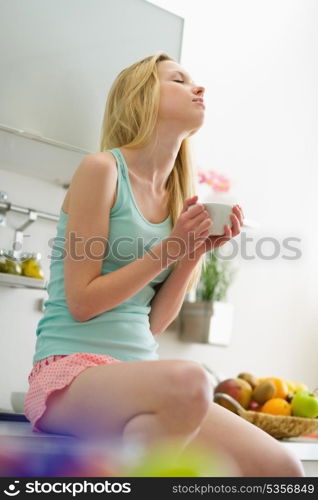 Young woman sitting in the morning and drinking coffee