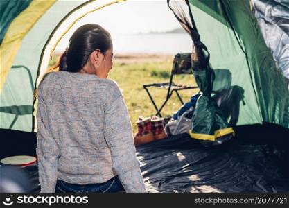 Young woman sitting looking out camping tent on travel outdoor holiday summer