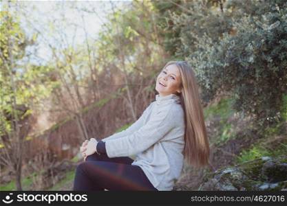 Young woman sitting on a big stone in a relaxed day