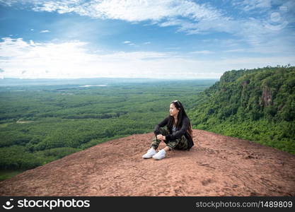 Young woman sitting on a mountain top at Phu Sing, Hin Sam Wan, Buengkan, Thailand