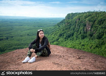 Young woman sitting on a mountain top at Phu Sing, Hin Sam Wan, Buengkan, Thailand