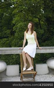 Young woman sitting on a railing