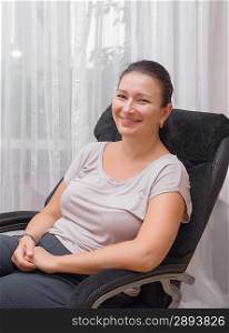 Young woman sitting on chair smiling