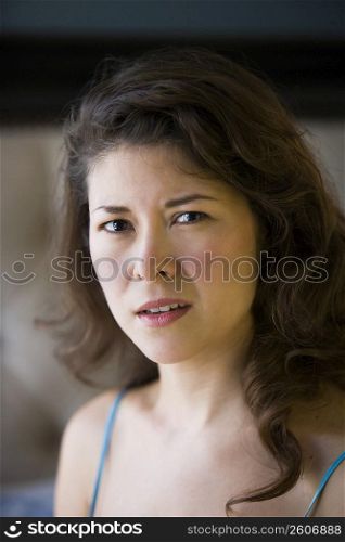Young woman sitting on edge of bed