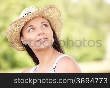 young woman sitting on grass in park enjoying the sunshine