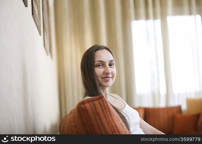 Young woman sitting on sofa, portrait