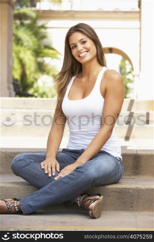 Young Woman Sitting On Steps Of Building
