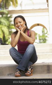 Young Woman Sitting On Steps Of Building