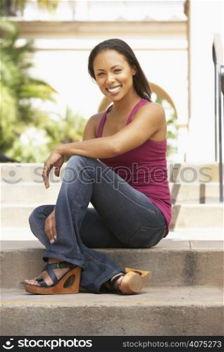 Young Woman Sitting On Steps Of Building