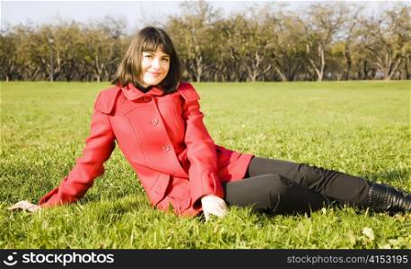 Young Woman Sitting On The Green Grass