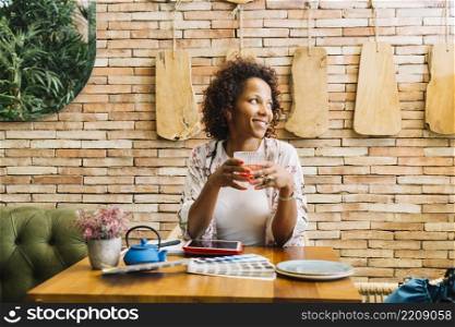 young woman sitting restaurant holding glass juice