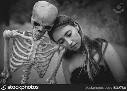young woman sitting road with skeleton looking down