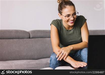 young woman sitting sofa using laptop