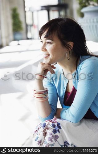 Young woman sitting with her hand on her chin