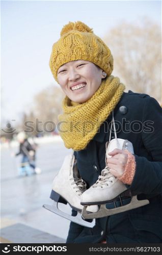 Young Woman Sitting with Ice Skates