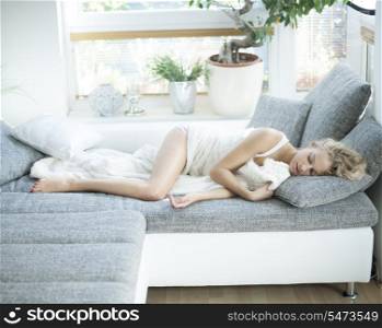 Young woman sleeping on sofa at home