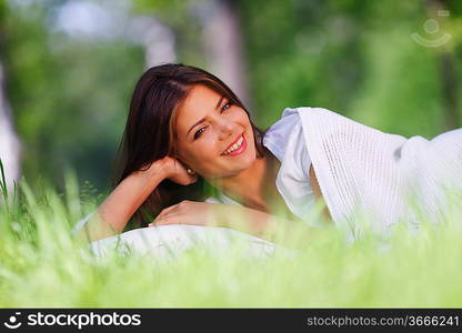 Young woman sleeping on soft pillow in fresh spring grass