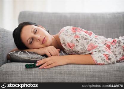 Young woman sleeping with pack of pills