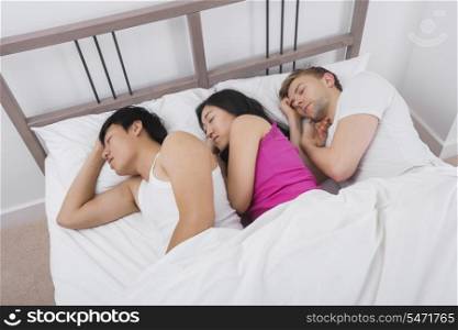 Young woman sleeping with two men in bed