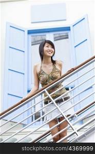 Young woman smiling and standing beside a railing