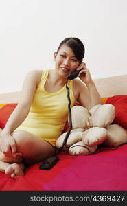 Young woman smiling and talking on the telephone