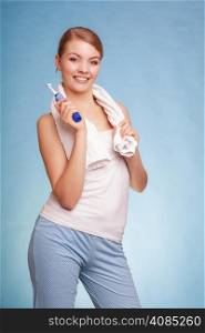 Young woman smiling girl with toothbrush brushing her white teeth on blue. Daily dental care. Studio shot.