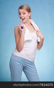 Young woman smiling girl with toothbrush brushing her white teeth on blue. Daily dental care. Studio shot.