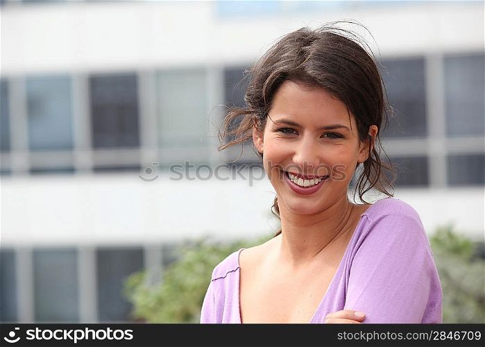 young woman smiling in front of a building
