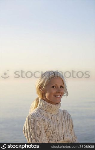 Young woman smiling on beach, portrait