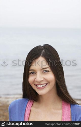 Young woman smiling standing on beach
