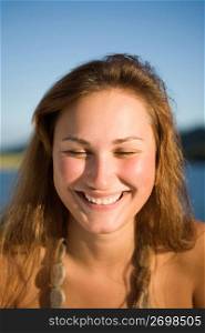 Young woman smiling, water in the background