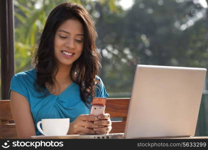 Young woman smiling while using cell phone