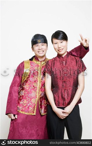 Young woman smiling with a young man making a peace sign