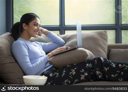 YOUNG WOMAN SMILING WORKING ON HER LAPTOP